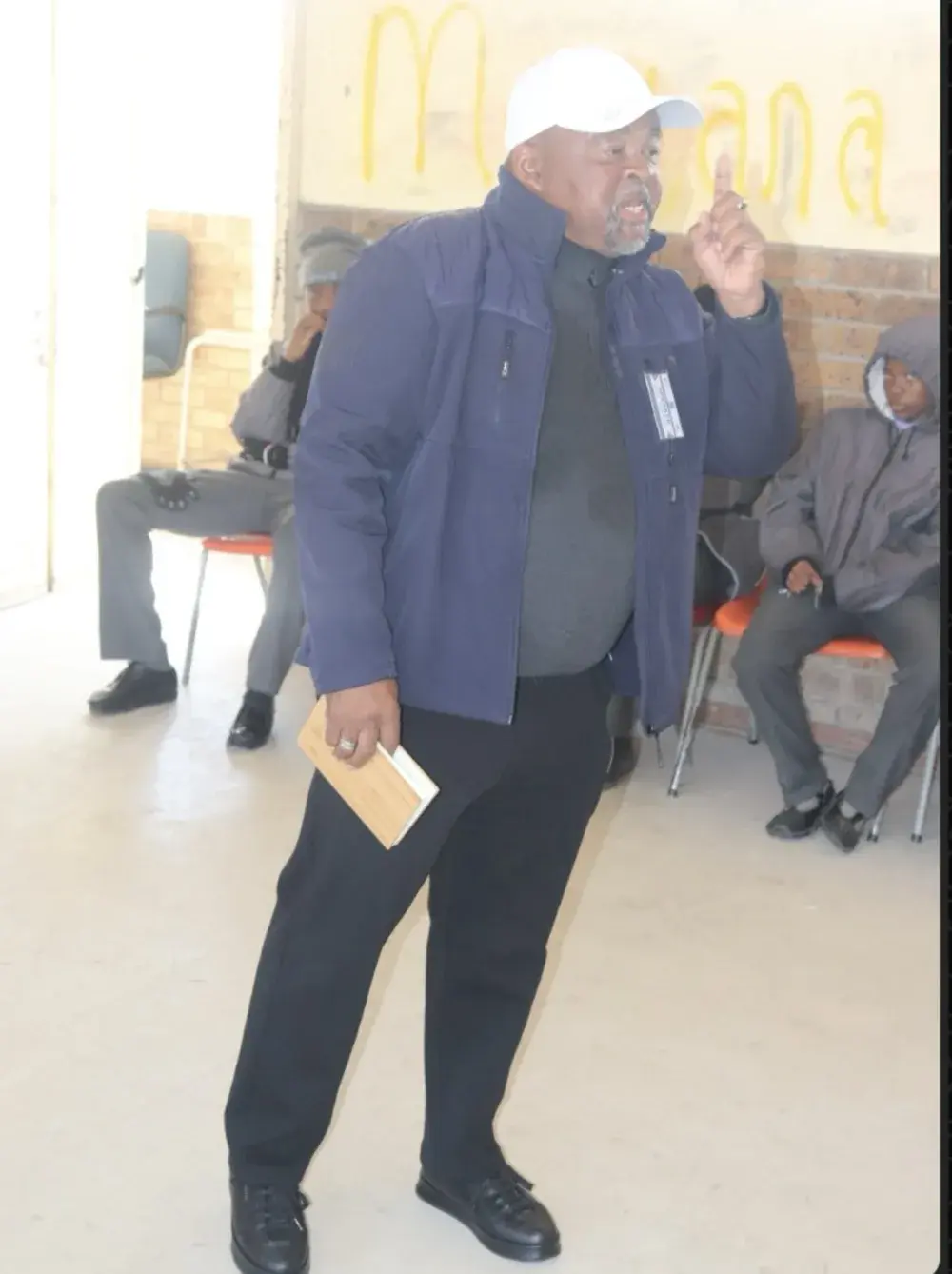 An alumnus speaker addressing learners in a school hall